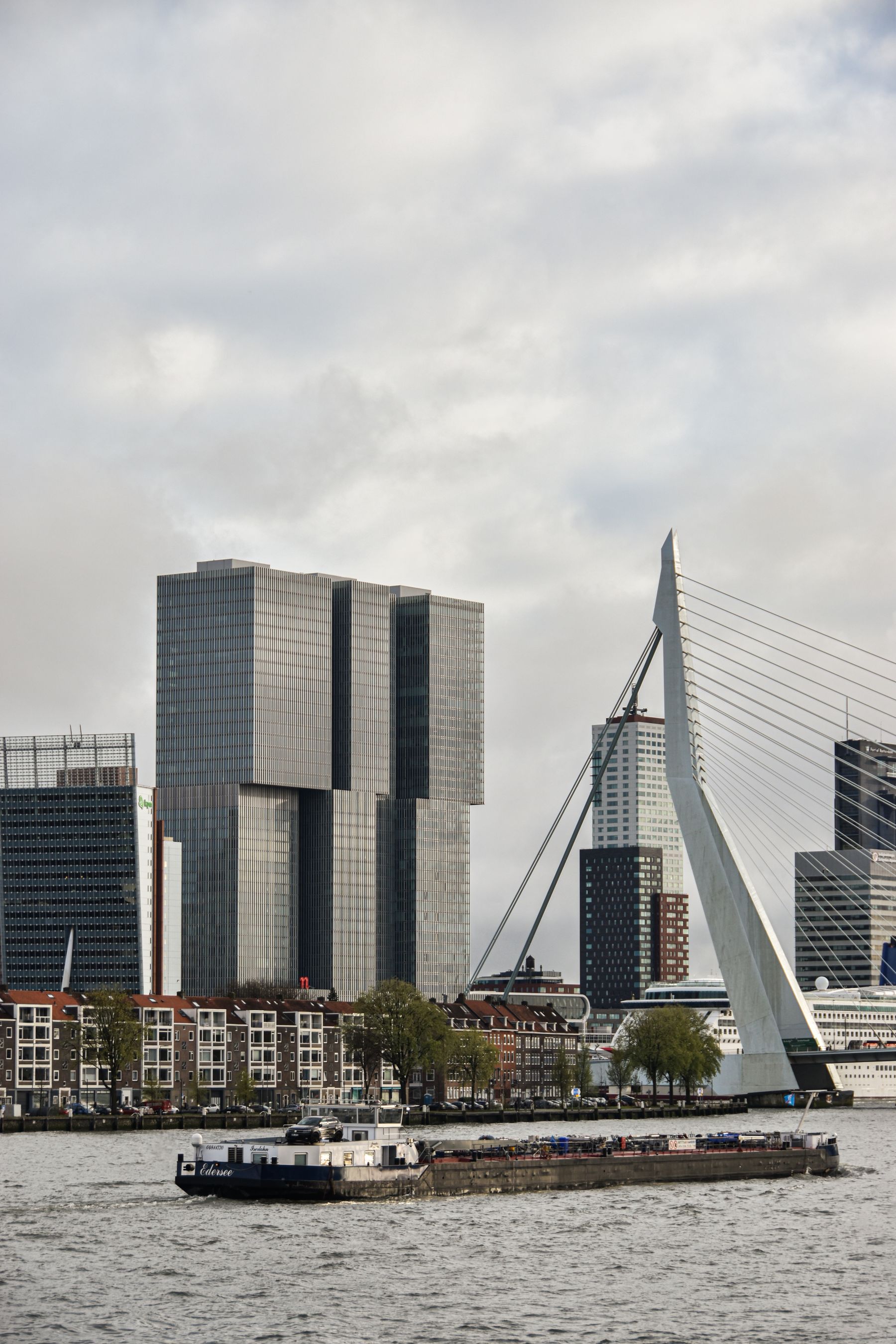 Moderne Gebäude, Erasmusbrücke und Frachtschiff am Rotterdamer Wasserweg